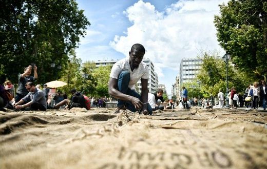 Ghanian artist Ibrahim Mahama performs "Check Point - Prosfygika" on the main Syntagma square in Athens on April 7, 2017 on the eve of the opening of the 14th edition of the Documenta 14 art exhibition