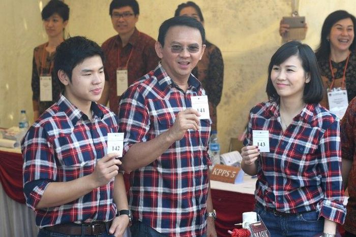 Jakarta's Christian governor Basuki Tjahaja Purnama (C), better known as "Ahok", flanked by his wife Veronica (R) and son Nicholas (L) show off their ballot papers in Jakarta on February 15, 2017