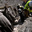A volunteer on the "blue helmet" brigade to rescue historic artwork cleans statues recovered from the San Francesco di Visso