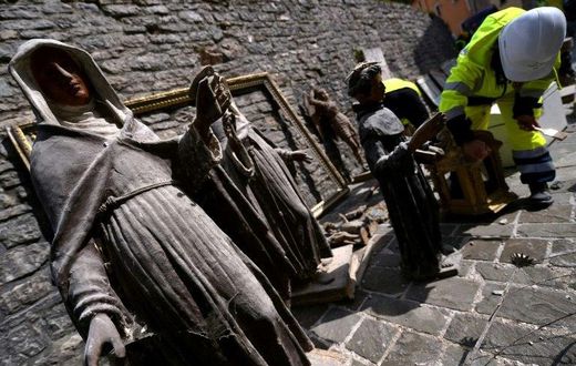 A volunteer on the "blue helmet" brigade to rescue historic artwork cleans statues recovered from the San Francesco di Visso
