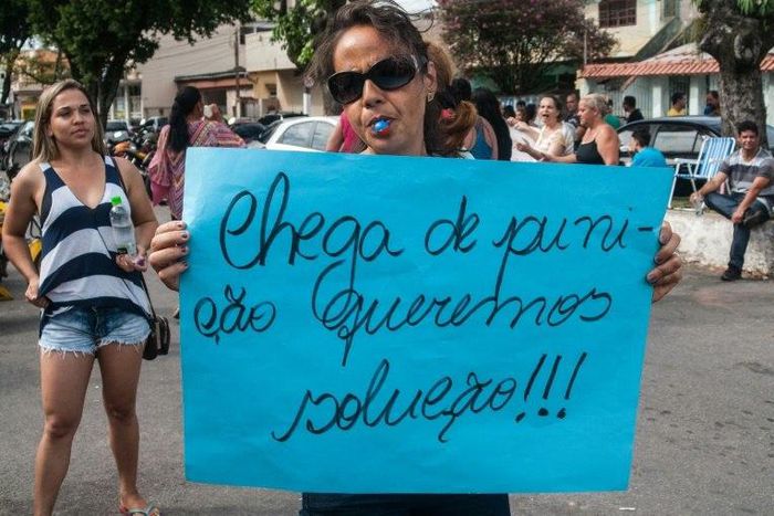A relative of a military police shows a sign reading "Enough of punishment, we want solutions!" during a protest in support of a police strike at the entrance of a police station in Vila Velha, near Vitoria, in eastern Brazil on February 6, 2017