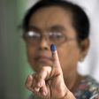 A woman shows her finger, which was inked after she cast her vote in a by-election, in a polling station in Yangon, Myanmar