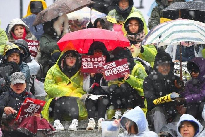 Protesters hold banners calling for the resignation of South Korean President Park Geun-Hye in central Seoul on November 26, 2016
