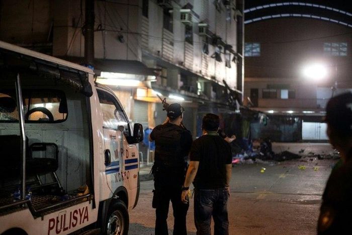 Philippines police officers look on just after an explosion in the Quiapo district of Manila, on May 6, 2017