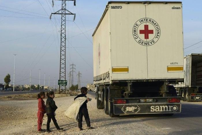 Syrian children gather around a lorry after an aid convoy of the International Committee of the Red Cross (ICRC) and the Syrian Arab Red Crescent entered the rebel-held town of Rastan, in central Homs province, on November 22, 2016