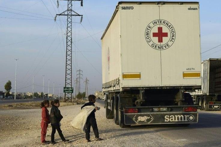 Syrian children gather around a lorry after an aid convoy of the International Committee of the Red Cross (ICRC) and the Syrian Arab Red Crescent entered the rebel-held town of Rastan, in central Homs province, on November 22, 2016