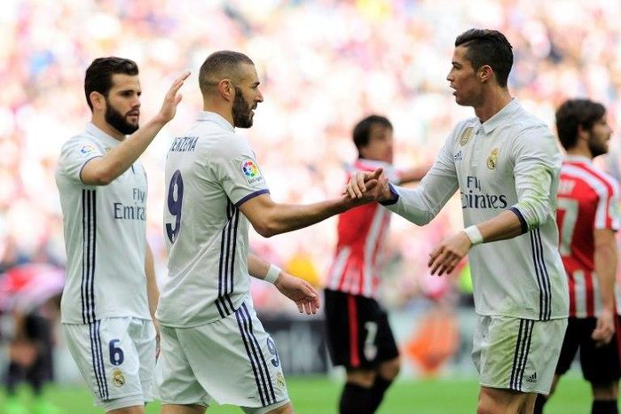 Real Madrid's forward Karim Benzema (C) is congratulated by teammates Cristiano Ronaldo (R) and defender Nacho Fernandez after scoring on March 18, 2017