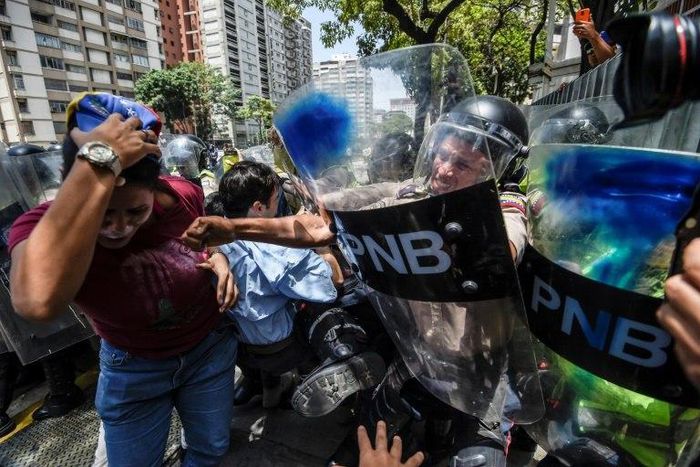 An estimated 1,000 people scuffled with police as they tried to march to Venezuela's National Assembly to demand the government restore powers to its opposition majority