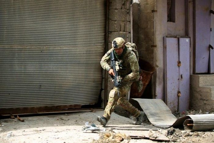 An Iraqi soldier runs for cover as government forces battle Islamic State group jihadists for control of Mosul's Old City