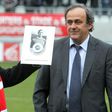This photo taken on February 5, 2011 shows former French former soccer legend Raymond Kopa (L) posing with the UEFA prize handed by the then UEFA president Michel Platini (R) prior to the French L2 football match Reims versus Le Havre in Reims