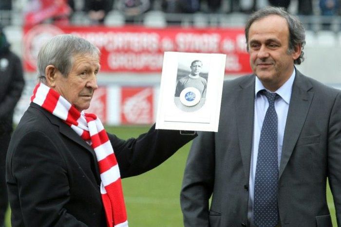 This photo taken on February 5, 2011 shows former French former soccer legend Raymond Kopa (L) posing with the UEFA prize handed by the then UEFA president Michel Platini (R) prior to the French L2 football match Reims versus Le Havre in Reims