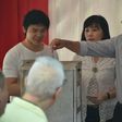 Incumbent Jakarta governor Basuki Tjahaja Purnama casts his ballot next to his wife Veronica and son Nicholas at a polling station on April 19, 2017