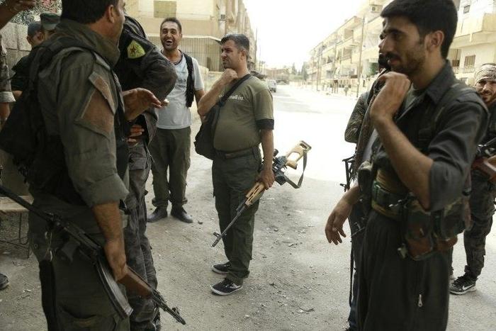 Members of the Kurdish police and the Kurdish People's Protection Units(YPG) patrol in the northeastern Syrian city of Hasakeh