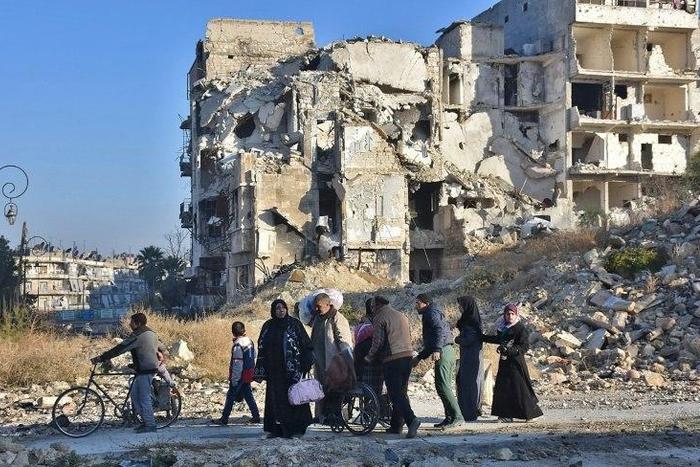 Syrian residents fleeing the violence in the eastern rebel-held parts of Aleppo evacuate from their neighbourhoods through the Bab al-Hadid district after it was seized by the government forces, on December 7, 2016