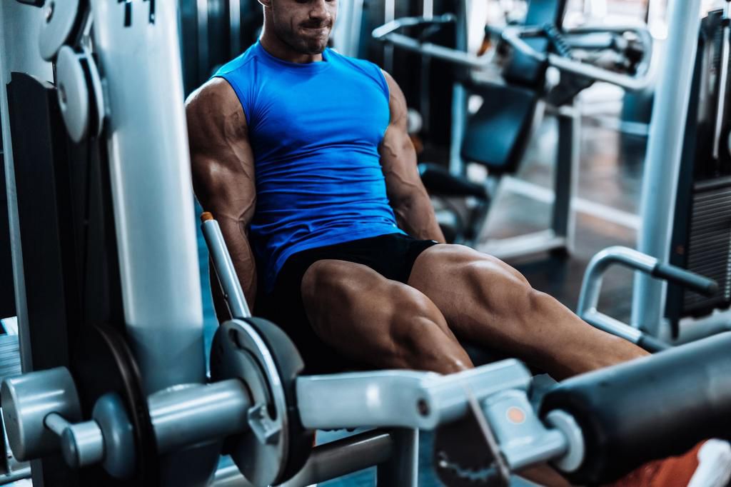 Young man exercising legs in the local gym