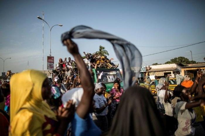 Supporters of Adama Barrow, flag-bearer of the coalition of the seven opposition political parties in Gambia, gather in the streets of Talinding on the outskirts of Banjul on November 25, 2016 to try to catch a glimpse of the candidate's motorcade