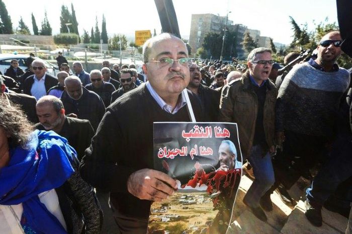 Arab Israeli Knesset (Israeli parliament) member Ahmad Tibi carries a sign in Arabic reading "Here is Negev" in protest at demolitions carried out by authorities in Arab neighbourhoods, in front of the Knesset in Jerusalem on January 23, 2017