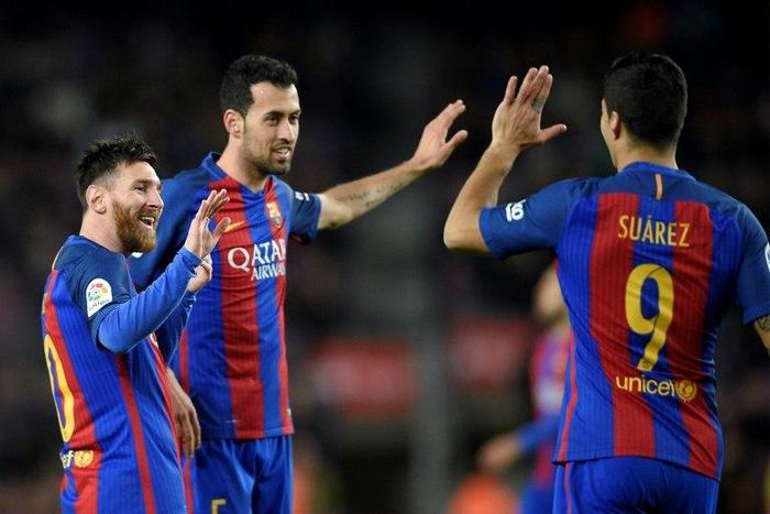 Barcelona's Lionel Messi (L) celebrates with Sergio Busquets (C) and Luis Suarez after scoring during their match against Sporting de Gijon at the Camp Nou stadium in Barcelona on March 1, 2017