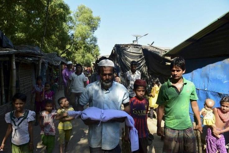 A man carries the body of six-month-old Alam for his burial in a refugee camp in Teknaf, in Bangladesh, on November 26, 2016