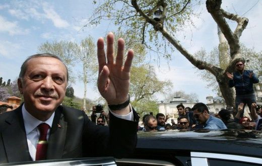 Turkish President Recep Tayyip Erdogan (L) greeting supporters during his visit to the Eyup Sultan Mosque in Istanbul the day after his victory in a national referendum on April 17, 2017
