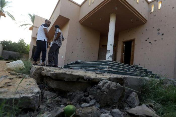 Libyans examine the site where a mortar shell landed in Tripoli during a previous round of deadly clashes between militias on August 30, 2018