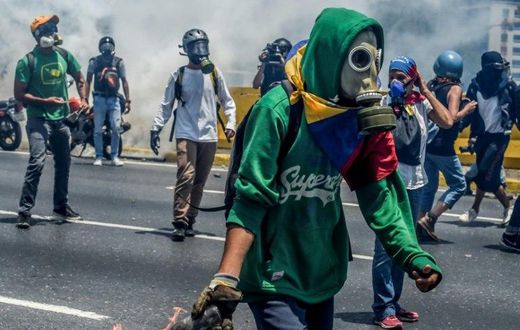 Venezuelan opposition activists clash with riot police during a protest march against President Nicolas Maduro in Caracas on April 26, 2017