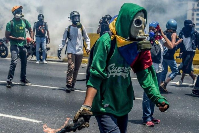 Venezuelan opposition activists clash with riot police during a protest march against President Nicolas Maduro in Caracas on April 26, 2017