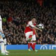 Arsenal's midfielder Mesut Ozil (R) shoots to score the opening goal of the English Premier League football match between Arsenal and West Ham United at the Emirates Stadium in London on April 5, 2017