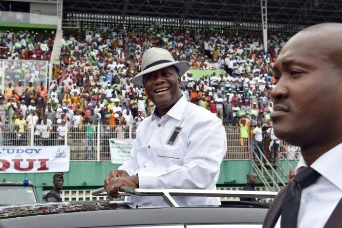 Ivory Coast's President Alassane Ouattara (C) smiles and greets supporters as he arrives for a rally on October 22, 2016, ahead of a referendum on the adoption of a new constitution