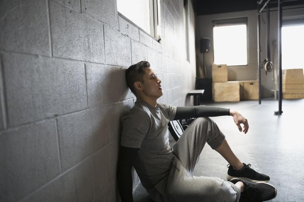 Tired man resting at gym