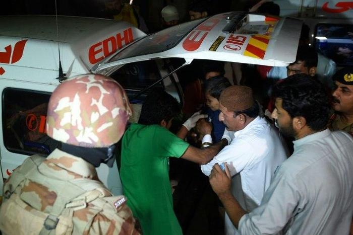 Volunteers move an injured blast victim from an ambulance at a hospital in the Hub district, some 40 kilometers from Karachi, on November 12, 2016