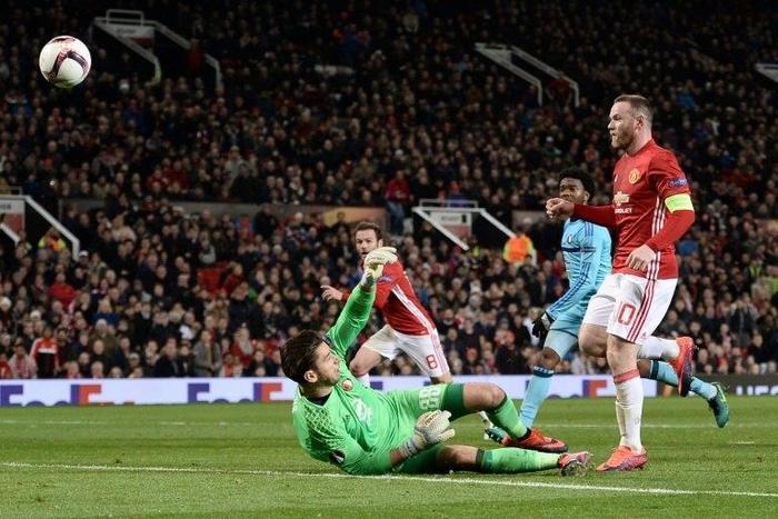 Manchester United's Wayne Rooney (R) chips the ball over Feyenoord's Australian goalkeeper Brad Jones (L) to score the opening goal against Feyenoord at Old rafford stadium in Manchester, north-west England, on November 24, 2016