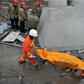 Workers carry a body on a stretcher from the remains of a collapsed platform in a cooling tower at a power station at Fengcheng in China's Jiangxi province on November 24, 2016