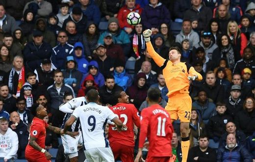 Liverpool's goalkeeper Simon Mignolet (R) punches the ball clear during the English Premier League football match between West Bromwich Albion and Liverpool at The Hawthorns stadium in West Bromwich, central England, on April 16, 2017