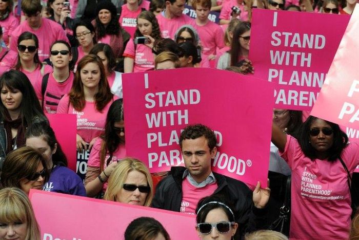 Participants shout slogans and display placards during a rally to "stand up for women's health" at the National Mall in Washington, DC