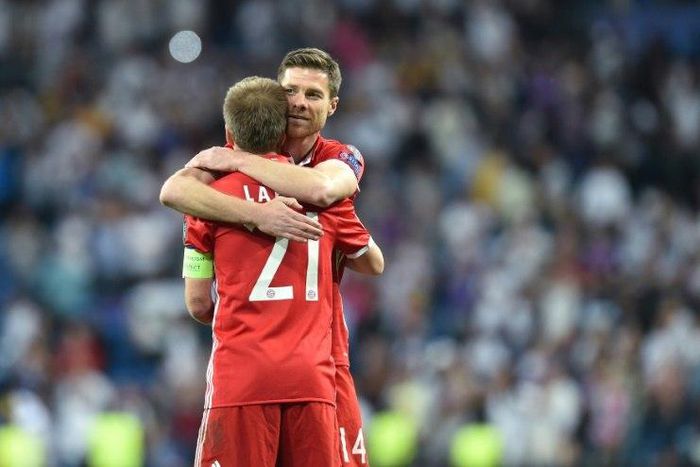 Bayern Munich's defender Philipp Lahm (L) hugs teammate Xabi Alonso (R) after their UEFA Champions League quarter-final second leg football match against Real Madrid at the Santiago Bernabeu stadium in Madrid on April 18, 2017