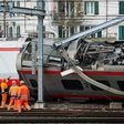 Police officers and workers inspect the site of a train crash at the train station of Lucerne where a Eurocity train of Trenitalia derailed on March 22, 2017 in Lucerne