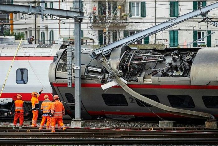 Police officers and workers inspect the site of a train crash at the train station of Lucerne where a Eurocity train of Trenitalia derailed on March 22, 2017 in Lucerne