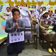 A man (L) wearing a mask of Japanese Prime Minister Shinzo Abe kneels down in a mock apology next to the statue (R) of a teenage girl symbolizing former "comfort women" who served as sex slaves for Japanese soldiers during World War II