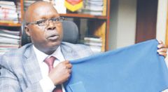 Prof. Kipkurgat holds up a sample of the fabric Rivatex will produce for new police uniforms (Standard)