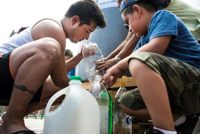 People get water during a drinking water supply cut in Santiago, on February 26, 2017