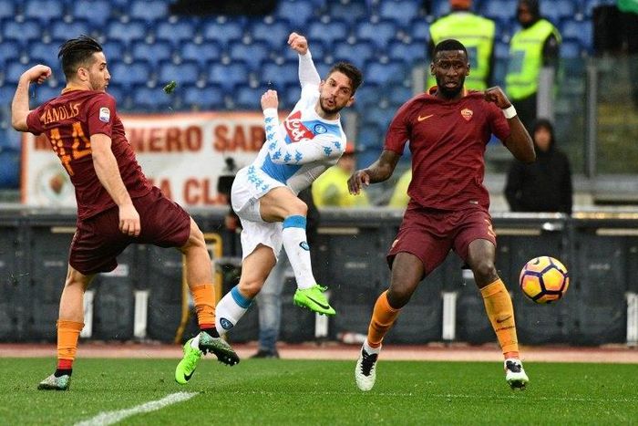 Makeshift Napoli forward Dries Mertens (C) shoots as Roma defenders Kostas Manolas (L) and Antonio Rudiger look on during Italian Serie A match at the Olympic Stadium in Rome on March 4, 2017