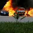 A photographer capturing images of cars burning after they were bombed at Dusit complex