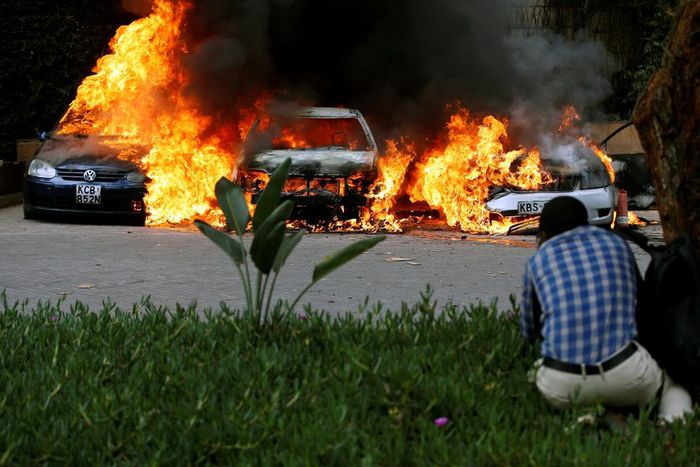 A photographer capturing images of cars burning after they were bombed at Dusit complex