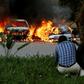 A photographer capturing images of cars burning after they were bombed at Dusit complex