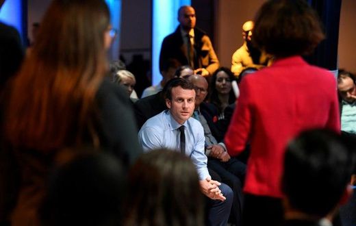 French presidential candidate Emmanuel Macron listens to people during a campaign rally in the tough Paris suburb of Saint-Denis