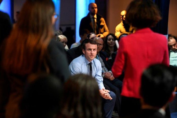 French presidential candidate Emmanuel Macron listens to people during a campaign rally in the tough Paris suburb of Saint-Denis