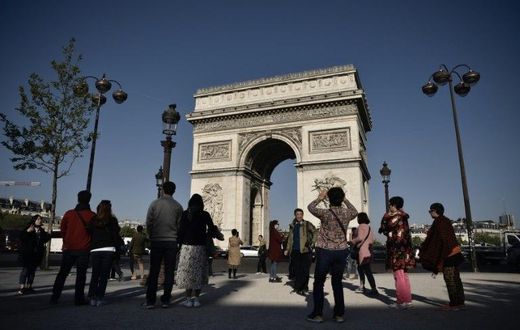 Tourists returned to the Champs Elysees on Friday, with many vowing that the killing of a policeman on the world-famous avenue would not stop them from coming