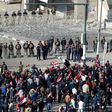 Iraqi security forces stand guard as supporters of the Sadrist movement gather during a demonstration in Baghdad's Tahrir Square on February 11, 2017, to demand the formation of an independent electoral commission