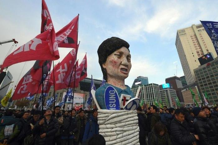 South Korean protesters carry an effigy of President Park Geun-Hye during an anti-government rally in Seoul, on November 30, 2016